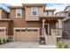 Inviting two-story home features a front-entry garage, covered porch, and neutral brown siding at 16432 Snowbourn Dr, Parker, CO 80134