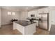Modern kitchen boasts white cabinets, stainless steel appliances, a gray countertop island, and wood floors at 16432 Snowbourn Dr, Parker, CO 80134