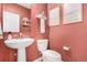 Charming powder room with vessel sink, stylish fixtures, and warm coral colored walls at 16432 Snowbourn Dr, Parker, CO 80134