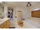 Bright bathroom featuring a soaking tub, custom light fixture, window, and decorative shelving unit at 22921 E Euclid Cir, Aurora, CO 80016