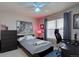 Bedroom with neutral paint, a ceiling fan, a large window, and a black accent wall at 22921 E Euclid Cir, Aurora, CO 80016
