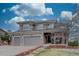 Charming two-story home featuring a three-car garage and a landscaped front yard under a cloudy sky at 22921 E Euclid Cir, Aurora, CO 80016