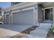 Attached three car garage features stone accents and well lit front door at 22921 E Euclid Cir, Aurora, CO 80016