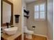 This cozy powder room features a wooden vanity, vessel sink, and charming decor at 22921 E Euclid Cir, Aurora, CO 80016