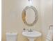 Half bathroom with tiled mirror, pedestal sink, and toilet at 3000 E 112 Ave # 102, Northglenn, CO 80233