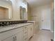 Bright bathroom featuring a double vanity with a granite countertop, tile backsplash, and a separate soaking tub at 3000 E 112 Ave # 102, Northglenn, CO 80233
