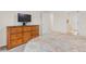 Bedroom with dresser, television, and doorway leading to bathroom and stairway at 3000 E 112 Ave # 102, Northglenn, CO 80233