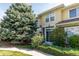 Exterior view of two-story home with stone accents, mature trees, and manicured shrubs at 3000 E 112 Ave # 102, Northglenn, CO 80233