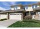 Charming townhome exterior with a stone-accented garage, front yard landscaping, and neutral color scheme at 3000 E 112 Ave # 102, Northglenn, CO 80233