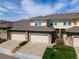 Two-story townhome features attached garages, stone accents, and a well-maintained lawn at 3000 E 112 Ave # 102, Northglenn, CO 80233