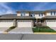 Street view of attached townhomes with private garages and manicured lawns at 3000 E 112 Ave # 102, Northglenn, CO 80233