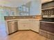 Kitchen featuring stainless steel dishwasher, stove, microwave, farmhouse sink, mosaic backsplash and light wood flooring at 3000 E 112 Ave # 102, Northglenn, CO 80233