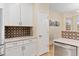 Kitchen featuring white cabinetry, decorative backsplash, and stainless steel appliances, for a modern touch at 3000 E 112 Ave # 102, Northglenn, CO 80233