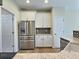 Bright kitchen featuring stainless steel refrigerator, white cabinets, mosaic tile backsplash and light wood flooring at 3000 E 112 Ave # 102, Northglenn, CO 80233