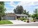 Charming single-story home with well-maintained landscaping, a driveway, and a modern garage door at 2998 S Adams St, Denver, CO 80210