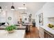 Bright, open kitchen and dining area featuring modern lighting, hardwood floors, and stainless steel appliances at 2998 S Adams St, Denver, CO 80210