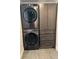 Modern laundry room featuring gray stacked washer and dryer and storage cabinetry at 2998 S Adams St, Denver, CO 80210