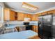 View of kitchen featuring wood cabinets, laminate counters, and black appliances at 16215 E Brunswick Dr, Aurora, CO 80013
