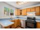 View of kitchen featuring wood cabinets, laminate counters, and black appliances at 16215 E Brunswick Dr, Aurora, CO 80013
