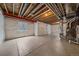 Unfinished basement with white walls, concrete flooring, and exposed ceiling beams at 8268 Mt Harvard Rd, Littleton, CO 80125