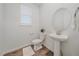 Clean powder room with a pedestal sink, round mirror, modern faucet, and a window with blinds at 8268 Mt Harvard Rd, Littleton, CO 80125