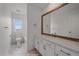 Well-lit bathroom featuring a vanity with a large mirror, white cabinets, and marble floor at 8268 Mt Harvard Rd, Littleton, CO 80125
