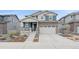 Charming two-story home featuring stone accents, gray siding, a two-car garage, and manicured landscaping at 8268 Mt Harvard Rd, Littleton, CO 80125