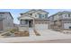 Charming two-story home featuring stone accents, gray siding, a two-car garage, and manicured landscaping at 8268 Mt Harvard Rd, Littleton, CO 80125