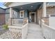 Close-up view of the home's porch that features stone column bases, a gray front door and a covered porch at 8268 Mt Harvard Rd, Littleton, CO 80125
