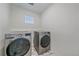 Modern laundry room with side-by-side washer and dryer and a window at 8268 Mt Harvard Rd, Littleton, CO 80125