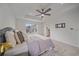 Well-lit bedroom with a tray ceiling, ceiling fan, soft carpeting, and a glimpse of the en-suite bathroom at 8268 Mt Harvard Rd, Littleton, CO 80125