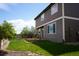 Backyard featuring a grassy lawn, trees, and the home's exterior with light-trimmed windows at 9616 Nucla St, Commerce City, CO 80022