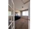 A bedroom with neutral walls, carpet flooring, a window, a door, and a mirror on top of a dresser at 9616 Nucla St, Commerce City, CO 80022