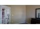 A bedroom with neutral walls, carpet flooring, a door, and a mirror on top of a dresser at 9616 Nucla St, Commerce City, CO 80022