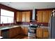 A kitchen with red walls, wood cabinets, stainless steel appliances and granite counter tops at 9616 Nucla St, Commerce City, CO 80022