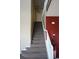 Carpeted staircase with white banister and red accent wall leading to the upper level at 9616 Nucla St, Commerce City, CO 80022