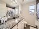 Bright bathroom featuring a granite vanity top, modern lighting, and a shower with decorative curtain at 3744 Celestial Ave, Castle Rock, CO 80109