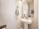Elegant powder room featuring a pedestal sink, large mirror, and neutral tones at 3744 Celestial Ave, Castle Rock, CO 80109