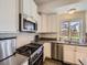 Well-lit kitchen showcasing stainless steel appliances, white cabinets, and stylish tile backsplash at 3744 Celestial Ave, Castle Rock, CO 80109