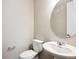 This half bathroom features a pedestal sink, a toilet, and a neutral color palette at 10557 Eby Cir, Lone Tree, CO 80124
