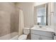 Tiled bathroom featuring a shower-tub combo and a modern single sink vanity at 10557 Eby Cir, Lone Tree, CO 80124