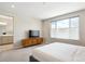 Bright bedroom featuring a plush bed, modern dresser, and an ensuite bathroom at 10557 Eby Cir, Lone Tree, CO 80124