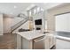 Bright open-concept kitchen featuring white cabinets, stainless steel appliances, and a kitchen island at 10557 Eby Cir, Lone Tree, CO 80124