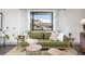 Inviting living room featuring a comfortable green sofa and a view of the neighborhood through the window at 11896 W 107Th Ave, Westminster, CO 80021