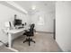 Bright, carpeted home office featuring a large electric desk and a comfortable office chair and a large window at 11896 W 107Th Ave, Westminster, CO 80021