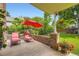 Relaxing patio area with lounge chairs and a red umbrella, set against a backdrop of a well-maintained lawn at 5988 E Jamison Ln, Centennial, CO 80112