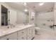 Well-lit bathroom featuring double sinks, a marble countertop, and a shower-tub combination at 5988 E Jamison Ln, Centennial, CO 80112