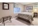 Cozy bedroom with a patterned bedspread, neutral walls, and soft carpet, illuminated by natural light at 5988 E Jamison Ln, Centennial, CO 80112