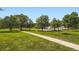 Scenic view of the community park featuring a paved path, grassy areas, and mature trees for recreational activities at 5988 E Jamison Ln, Centennial, CO 80112