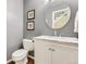 Stylish powder room featuring a sleek vanity with a marble countertop and decorative round mirror at 5988 E Jamison Ln, Centennial, CO 80112